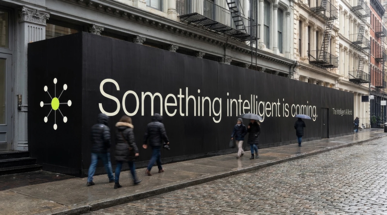 A SoHo hoarding reading Something intelligent is coming